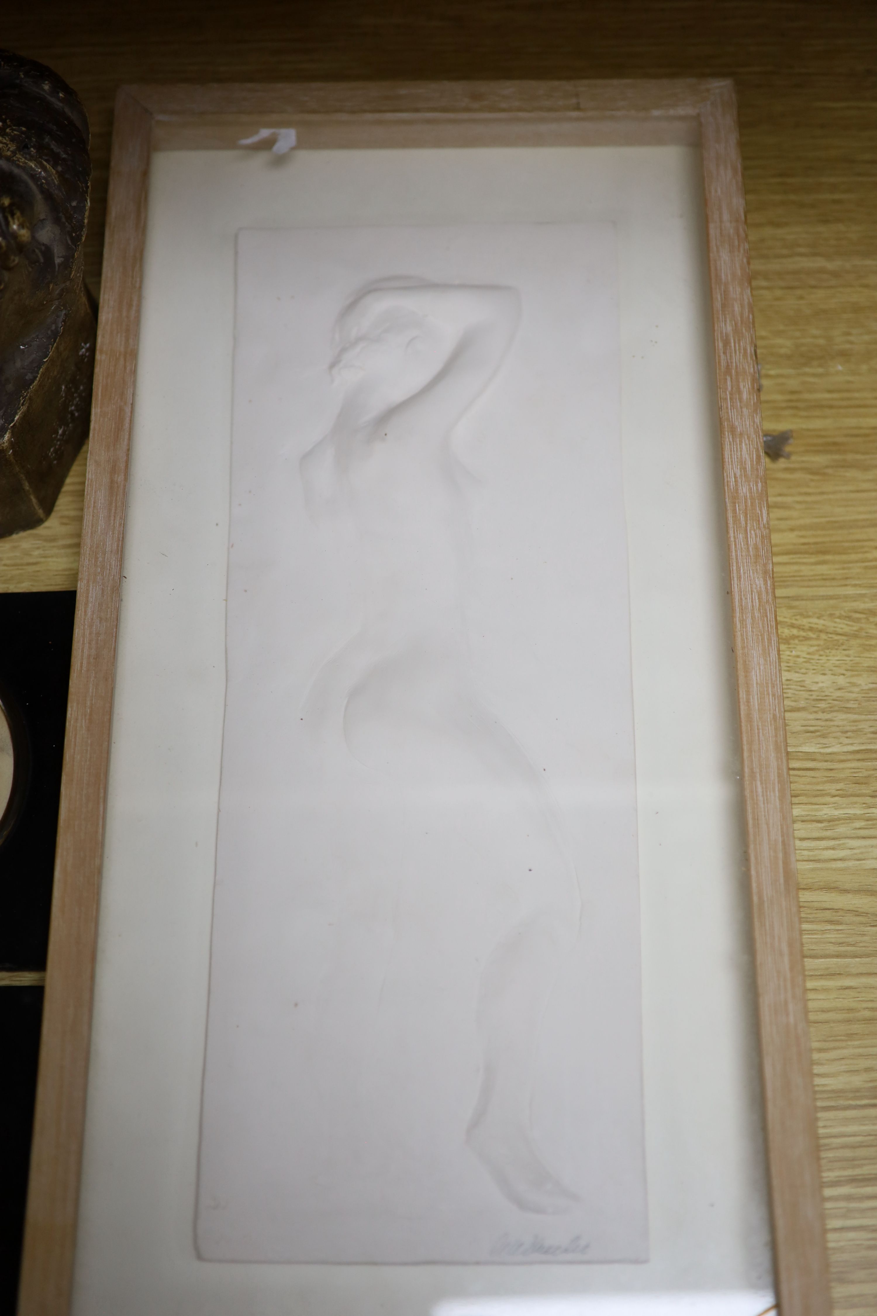 A pair of silhouettes, a plaster panel of a nude, indistinctly signed, and a plaster bust of a baby